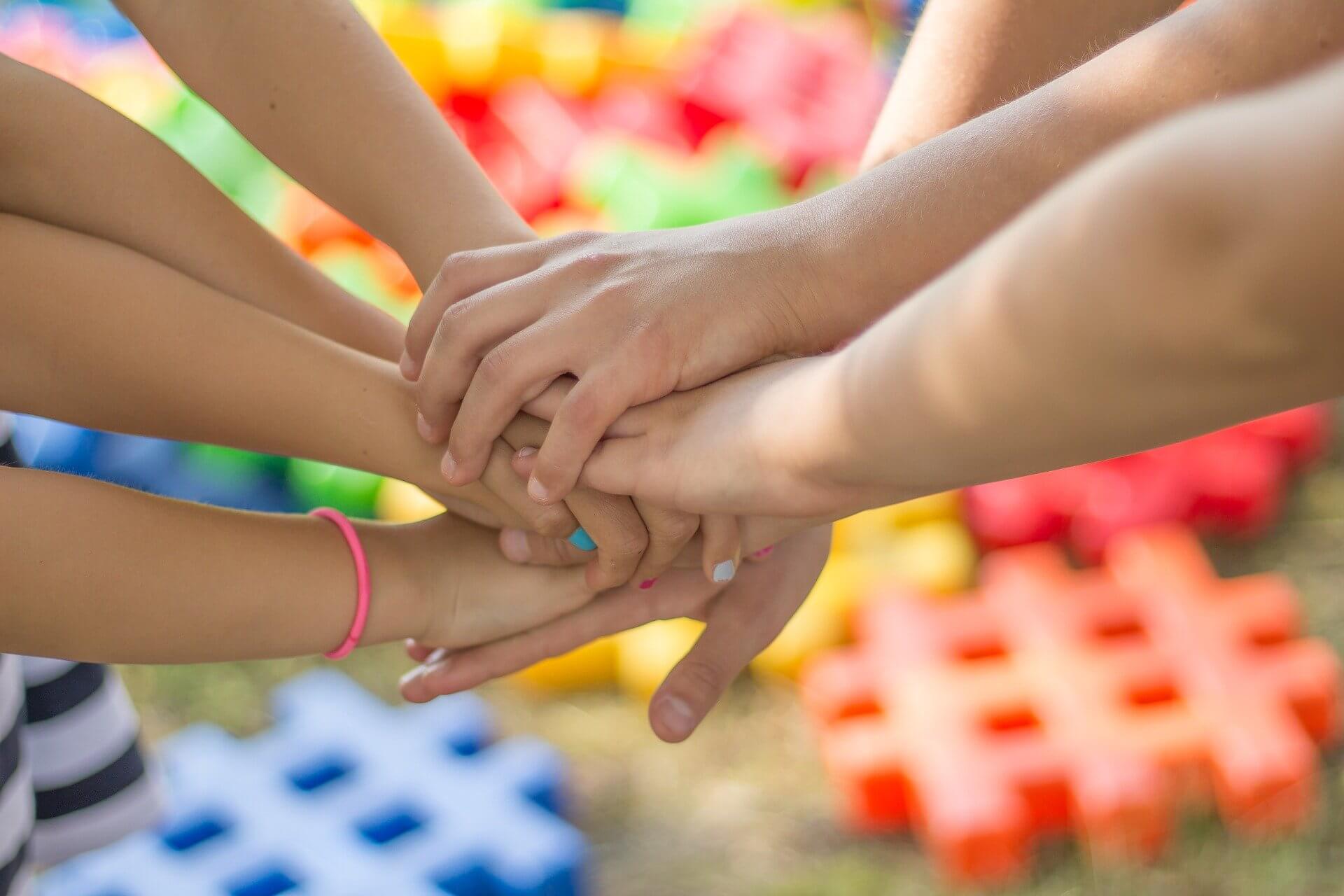 Kinder legen ihre Hände zusammen – Gemeinschaft und Zusammenhalt im Leader-in-Me-Programm